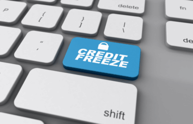 A computer keyboard with a blue key labeled CREDIT FREEZE, featuring a small padlock icon, amidst standard white keys.