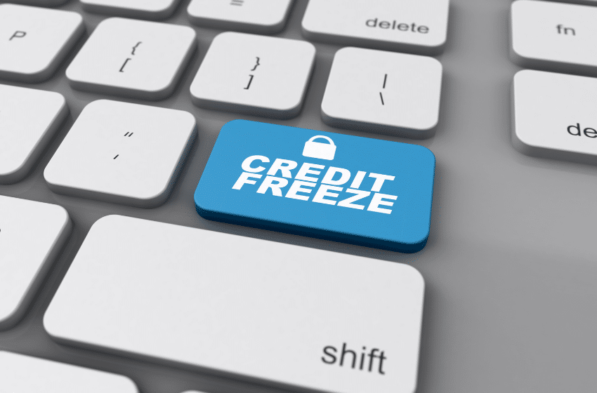 A computer keyboard with a blue key labeled CREDIT FREEZE, featuring a small padlock icon, amidst standard white keys.