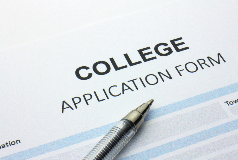 A close-up of a college application form with a pen resting on it. The form has sections for personal information. The word COLLEGE is prominently displayed at the top.