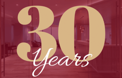 Large beige text on a transparent red overlay reads 30 Years, set against a background of a modern office space with wooden floors and bright lighting.