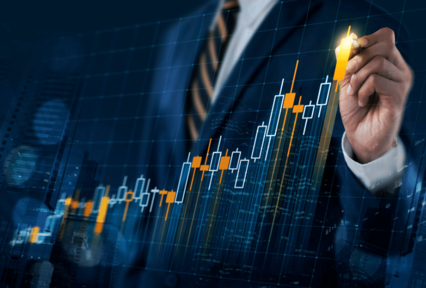 A person in a suit is drawing with a glowing pen on a digital screen, displaying a financial candlestick chart with rising data points. The background shows a cityscape, symbolizing growth and investment strategies.
