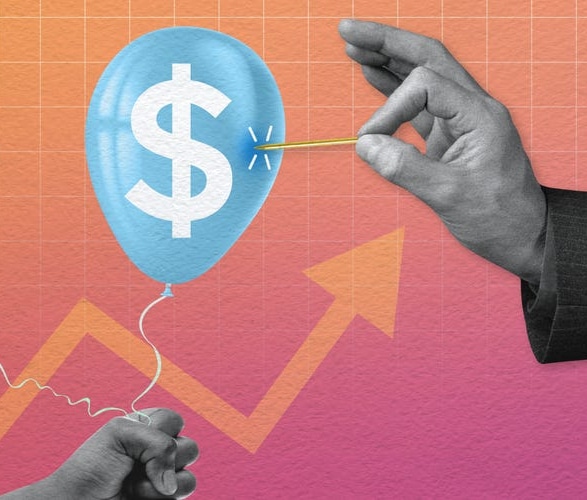 A hand holding a pin approaches a blue balloon with a dollar sign, against a colorful background with a rising arrow graph. The image symbolizes financial risk or economic change.