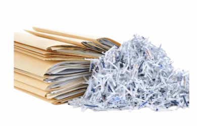 A stack of brown file folders filled with papers, next to a pile of shredded paper strips on a white background.