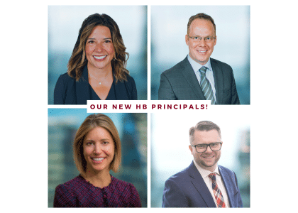 A composite image of four business professionals, two women and two men, each in individual headshots. Text in the center reads Our New HB Principals! The background is a soft blur of what appears to be office settings.