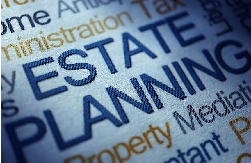 Close-up of assorted financial and legal terms printed in blue and orange text. The words ESTATE PLANNING are prominently featured in bold blue letters in the center.