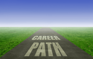 A long, straight road with the words CAREER PATH written on it stretches into the distance. The road is surrounded by green grass under a clear blue sky, symbolizing direction and opportunities.