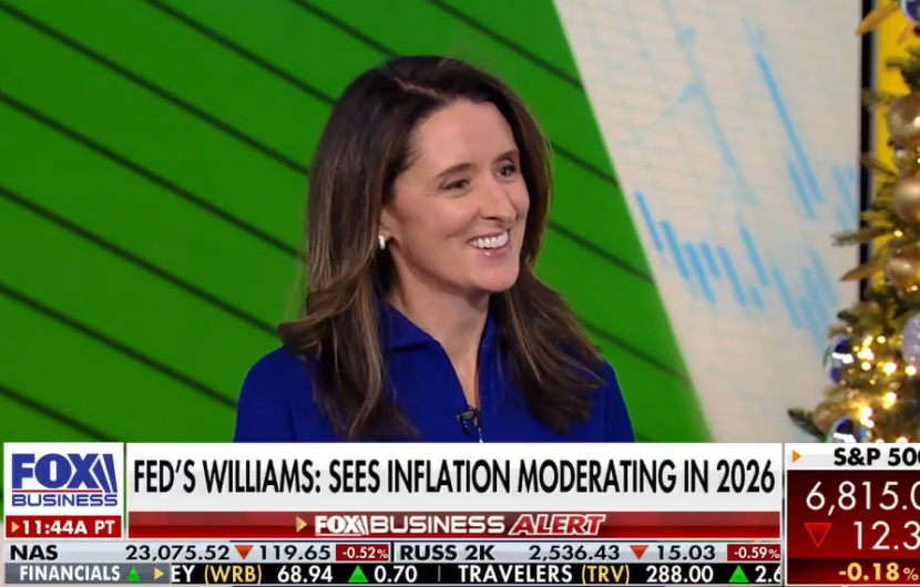 A woman in a blue top smiles while being interviewed on Fox Business. The headline reads, FEDS WILLIAMS: SEES INFLATION MODERATING IN 2026. Stock ticker information is displayed at the bottom of the screen.