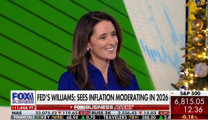 A woman in a blue top smiles while being interviewed on Fox Business. The headline reads, FEDS WILLIAMS: SEES INFLATION MODERATING IN 2026. Stock ticker information is displayed at the bottom of the screen.