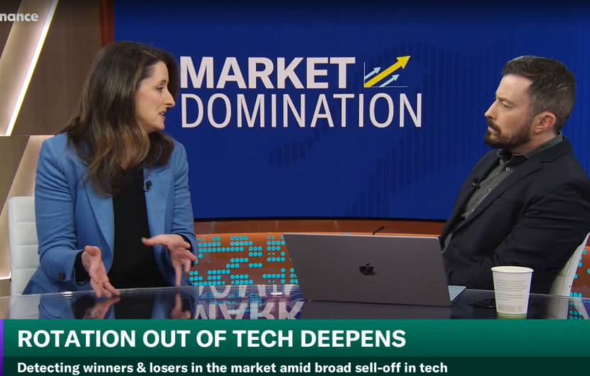 Two people sit at a news desk discussing Rotation Out of Tech Deepens on Yahoo Finances Market Domination, with a blue background and a laptop and coffee cup on the table.