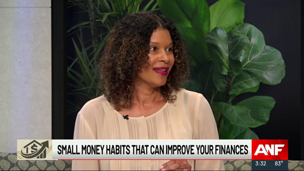 A woman with curly hair and a light blouse speaks on a TV show. The screen displays the text Small money habits that can improve your finances along with the ANF logo and the time and temperature at the bottom. Lush green plants are in the background.