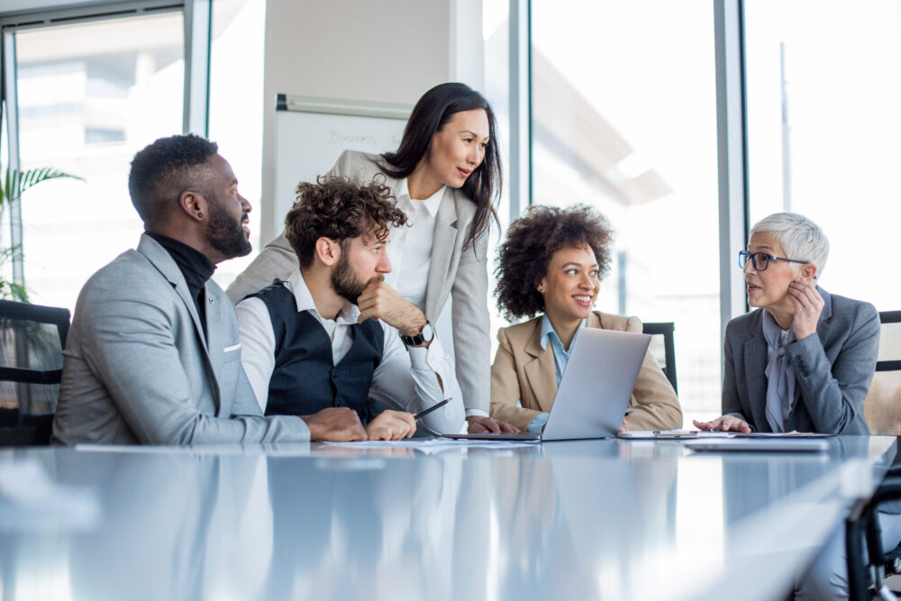 A mature CEO and her team of professionals having a briefing before the work.