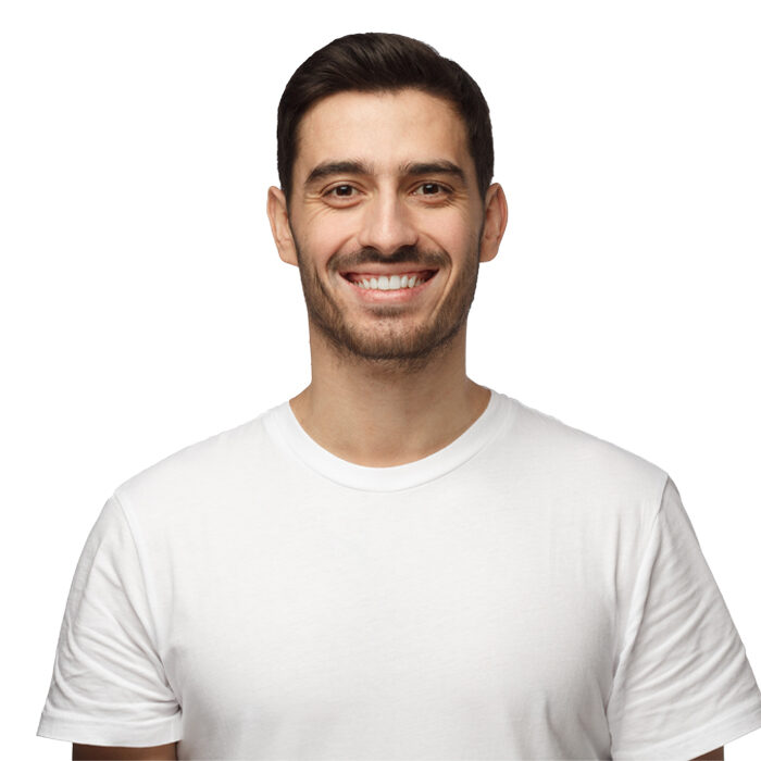A man with short dark hair and a beard smiles at the camera. He is wearing a plain white t-shirt and is standing against a white background.